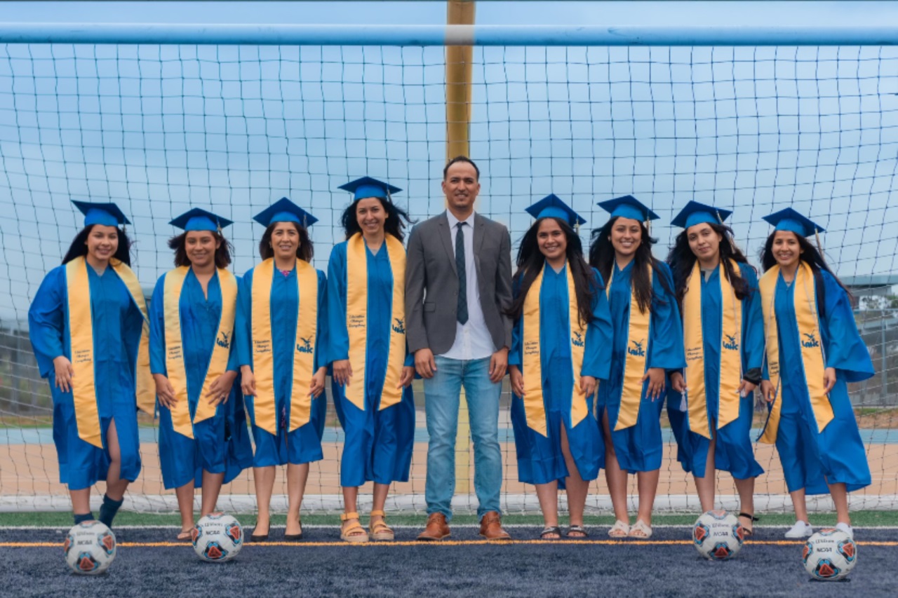 LA Harbor College women's soccer head coach Arturo Caballero stands with eight of his 13 players graduating with AA degrees and dean honors this year.